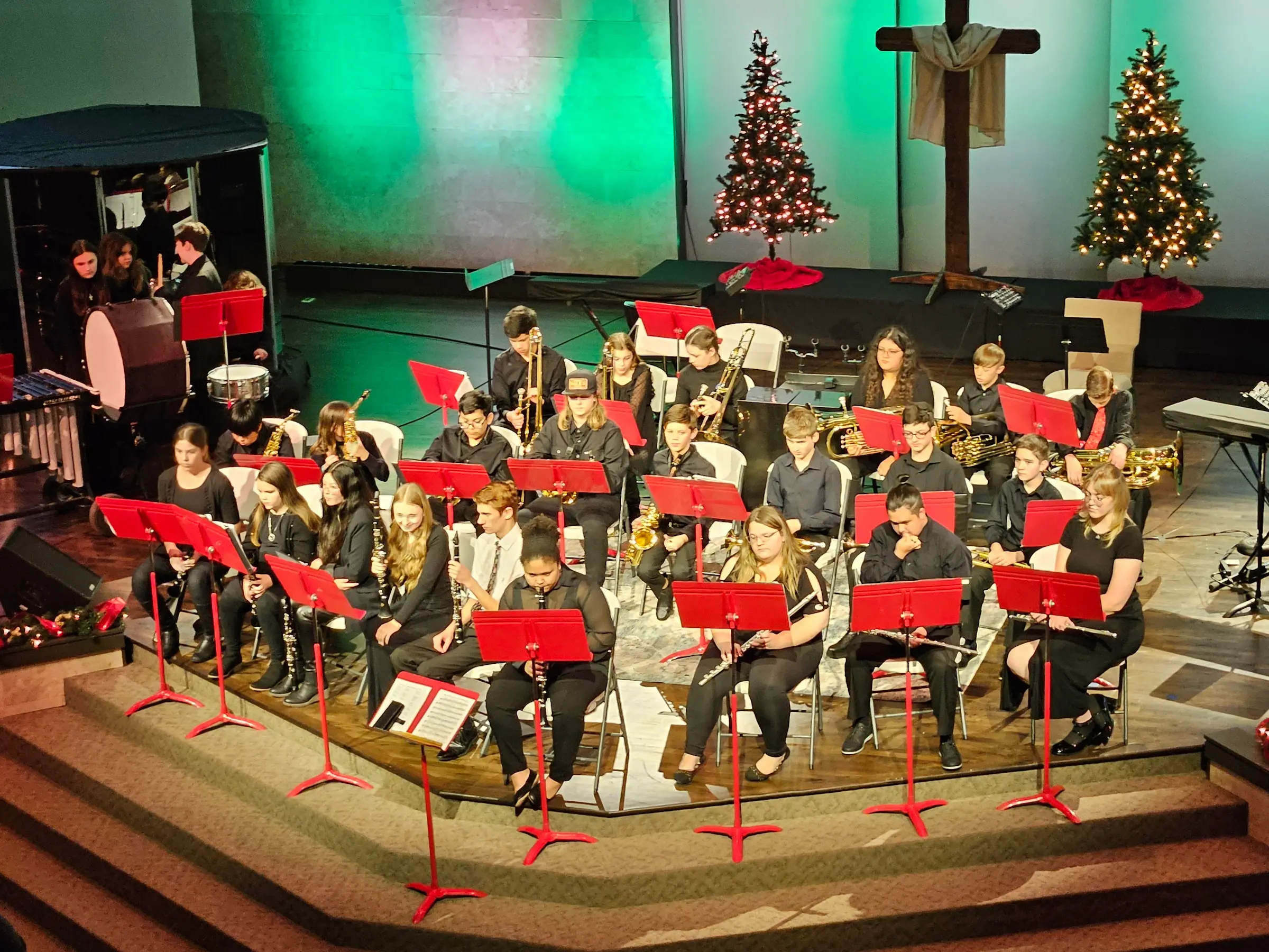 Orchestra performing on stage with Christmas decorations.