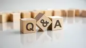 Wooden blocks spelling Q&A on table.