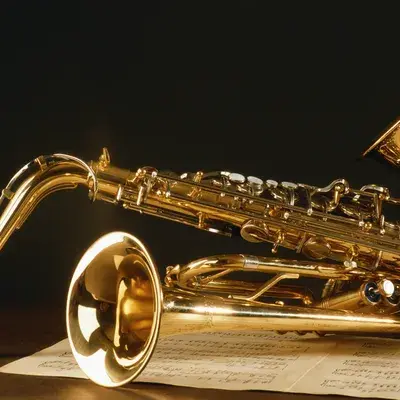 A shiny saxophone lying on a wooden surface.